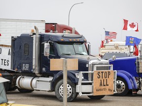 Anti-mandate demonstrators gather as a truck convoy blocks the highway the busy U.S. border crossing in Coutts, Alta., Monday, Jan. 31, 2022.