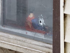 Ein Einschussloch ist in einem Fenster neben einer Superman-Actionfigur in einer Kellerwohnung in den Metro 105 Apartments, 10724 105 Street, zu sehen.