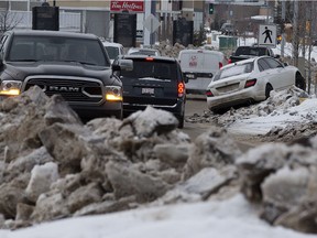 A vehicle is pictured stuck on a windrow along Maple Road NW and 12 Street NW in Edmonton on Thursday Feb. 3, 2022.