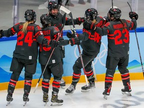 Team Canada’s Sarah Fillier is congratulated by teammates after scoring against Switzerland at the 2022 Winter Olympics.