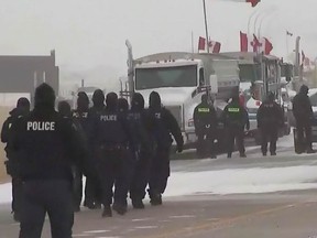 RCMP approach protesters and truckers at the Coutts border blockade on Tuesday, Feb. 1, 2022.