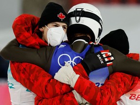 Canada's Mackenzie Boyd-Clowes (C) celebrates with teammates after his third place finish in the Ski Jumping Mixed Team Final.