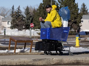 Chris Lalonde sits on a toilet in a shopping cart as he waits for his friend to pick him up near 28 Avenue and Lakewood Road E Northwest in Edmonton, on Wednesday March 16, 2022.