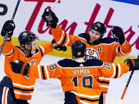 The Edmonton Oilers' Jesse Puljujarvi (13), Zach Hyman (18) and Leon Draisaitl (29) celebrate a third period goal against the New Jersey Devils at Rogers Place in Edmonton on Saturday March 19, 2022. The Oilers won 6 to 3.