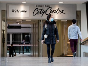 Pedestrians make their way across a pedestrian walkway between City Centre Mall and Manulife Place, in downtown Edmonton, Friday, March 25, 2022.