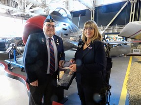 David Jackson, chairman of the board of directors at 700 Wing RCAF Association, left, presents a cheque for $20,000 to Jean Lauzon, executive director of the Alberta Aviation Museum.