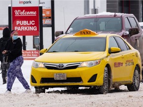 A rider gets out of a Yellow Cab taxi in downtown Edmonton, on Saturday, March 5, 2022. Advocacy groups are demanding action to improve safety and accessibility in taxis and rideshare services.