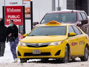 A rider gets out of a Yellow Cab taxi in downtown Edmonton, on Saturday, March 5, 2022. Advocacy groups are demanding quicker action to improve safety and accessibility in taxis and rideshare services as a council committee is set to look at a report on the issue.