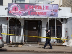 Ein Mitglied des Polizeidienstes von Edmonton untersucht am Samstag, den 12. März 2022, den Schauplatz einer Schießerei in der Nähe der 118 Avenue und der 125 Street.