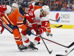 Edmonton Oilers defencemen Philip Broberg (86) and Detroit Red Wings forward Michael Rasmussen (27) battle for a loose puck during the second period at Rogers Place.