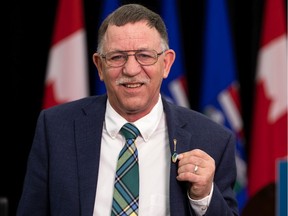 Alberta Culture Minister Ron Orr speaks about an amendment to the Emblems of Alberta Act to designate ammolite as the official gemstone of Alberta during a news conference in Edmonton, on Thursday, March 17, 2022. He's wearing an ammolite pin shaped like the province.