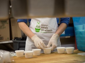 A volunteer prepares meals in the kitchen at Meals on Wheels at 11111 103 Ave. in Edmonton.