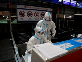 Airline staff wear personal protective equipment (PPE) to protect against COVID-19 as they work at Beijing Capital International airport in Beijing, March 13, 2022.