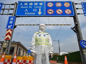 A transit officer, wearing a protective gear, controls access to a tunnel in the direction of financial district of Pudong in lockdown as a measure against the COVID-19 coronavirus, in Shanghai on March 28, 2022.