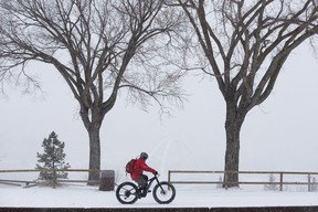 El domingo 20 de marzo de 2022, la nieve oscureció el horizonte de Edmonton cuando un ciclista pasó por Saskatchewan Drive en Edmonton.