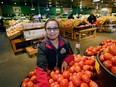 H&W Produce store employee Myrna Delosantos arranges some produce at the northeast Edmonton store. Food costs are continuing to rise in Canada.