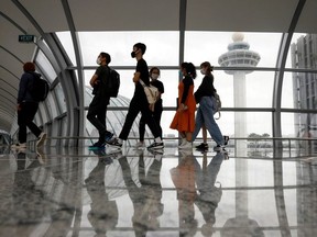 People pass the control tower of Singapore's Changi Airport, Singapore January 18, 2021.