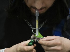 A man smokes "down" (fentanyl or carfentanil) in Edmonton's Central LRT station, Monday, March 28, 2022.