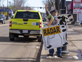 Dean Hill warns passing motorists about the photo radar truck that is stopped on 118 Avenue on Tuesday, March 22, 2022 in Edmonton.  He has been doing this for the past four years and has been charged with various offences for doing so.