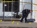 An Edmonton Police Service member investigates the scene of a shooting that left one dead and six injured at a lounge on 118 Avenue near 125 Street, Saturday, March 12, 2022.