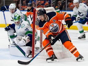 Zach Hyman #18 of the Edmonton Oilers brings the puck around the net as goaltender Spencer Martin #30 of the Vancouver Canucks defends the short side during the second period at Rogers Place on April 29, 2022.