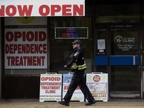 A pedestrian walks past advertisements for opioid dependence treatment outside the City Centre Clinic,10264 100 St., in Edmonton on Feb. 7, 2022.