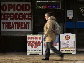 A pedestrian walks past advertisements for opioid dependence treatment outside the City Centre Clinic,10264 100 St., in Edmonton on Feb. 7, 2022.