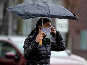 A pedestrian makes their way through a mixture of snow and rain near 87 Avenue and 114 Street in Edmonton, Wednesday, April 27, 2022.