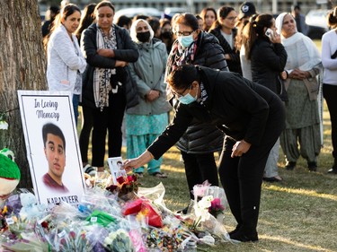 A photo is lain at a memorial as family and friends stand in silent vigil for Karanveer Sahota, who was beaten and stabbed to death outside McNally High School, during a vigil outside his school in Edmonton, on Friday, April 29, 2022.
