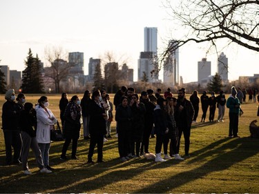Family and friends stand in silent vigil at a memorial for Karanveer Sahota, who was beaten and stabbed to death outside McNally High School, during a vigil outside his school in Edmonton, on Friday, April 29, 2022. Photo by Ian Kucerak