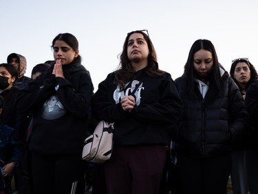 Family and friends pray for Karanveer Sahota, who was beaten and stabbed to death outside McNally High School, during a vigil outside his school in Edmonton, on Friday, April 29, 2022.