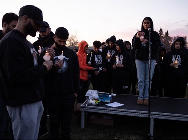 Shivleen Sidhu leads the crowd in a moment of silence in memory of Karanveer Sahota during a candlelight vigil held outside McNally High School in Edmonton, on Friday, April 29, 2022.