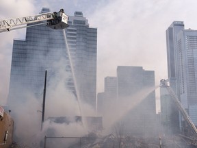 Edmonton Fire Rescue Services firefighters extinguish a fire in an abandoned building near 101 Street and 106 Avenue in Edmonton, on Sunday, April 10, 2022. A previous fire at the site destroyed the closed Mila Pub.