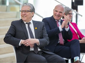 Federal Prairies Economic Development Canada Minister Daniel Vandal, left, and Tourism Minister Randy Boissonnault, Edmonton Centre Liberal MP, listen to a speaker during a federal announcement supporting community revitalization initiatives — including support for Edmonton's Downtown core, enhancing main streets and reinventing outdoor spaces on April 29, 2022.