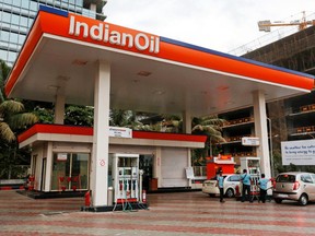 Employees refuel customers' vehicles at an Indian Oil Corp. gas station in Mumbai, India, on Monday, May 26, 2013.