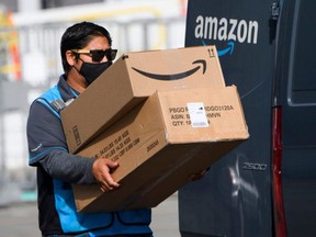 FILE: An Amazon.com Inc. delivery driver carries boxes into a van outside of a distribution facility on Feb. 2, 2021 in Hawthorne, Cali. / PHOTO BY PATRICK T. FALLON/AFP VIA GETTY IMAGES