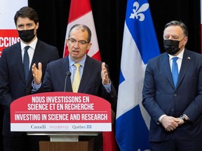 Prime Minister Justin Trudeau and Quebec Premier Francois Legault look on as Moderna's global CEO Stephane Bancel speaks during a news conference to announce the construction of a new Moderna mRNA vaccine production plant in Montreal. April 29, 2022. REUTERS/Christinne Muschi