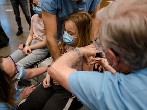 A child receives the Pfizer-BioNTech COVID-19 vaccine for children in Montreal on Nov. 24, 2021.