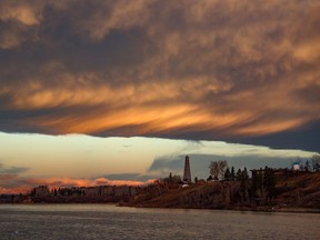 Sunrise with an interesting chinook-like arch of cloud created a dramatic scene over the Glenmore Reservoir and the oil derrick at Heritage Park in Calgary on Wednesday, November 3, 2021.