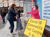 A woman is handed a free COVID-19 rapid test kit in London, England.