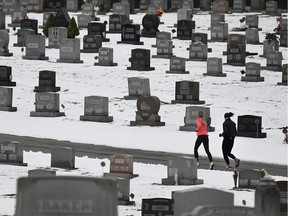 FILE - In this Friday, Jan. 24, 2020 file photo, two joggers run through Grandview Cemetery in Johnstown, Pa. Data released on Thursday, Jan. 30, 2020 shows that U.S. life expectancy has improved for the first time in four years, thanks to a sharp decline in the cancer death rate and to a drop in fatal drug overdoses.