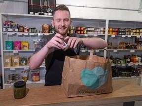 Too Good to Go, a new food app that matches restaurants/bakeries etc in an attempt to cut down food waste. Basically, the restaurants put up surprise bags of items that people can buy on the app for one-third of the price. Myles Fedun with Meuwly's Artisan Food Market puts items in a Too Good to Go paper bag.