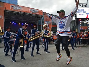 A jubilant fan leaps into the air as the Oilers Drum and Brass Crew performs for fans at the tailgate party in the ICE district Plaza prior to the start of the Oilers game two against the LA Kings in Edmonton, May 4, 2022.
