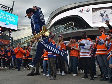 A member of the Oilers Drum and Brass Crew leaps into the air performing for fans at the tailgate party in the ICE district Plaza prior to the start of the Oilers game two against the LA Kings in Edmonton, May 4, 2022.