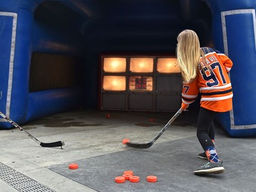 Chloe Ching, 10, firing the puck at the lite net targets as fans attend the tailgate party in the ICE district Plaza prior to the start of the Oilers game two against the LA Kings in Edmonton, May 4, 2022.