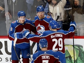 Cale Makar (8) of the Colorado Avalanche celebrates with Valeri Nichushkin (13) and Nathan MacKinnon (29) after scoring a goal against the Edmonton Oilers in Game 1 of the Western Conference final of the 2022 Stanley Cup playoffs at Ball Arena on May 31, 2022, in Denver.
