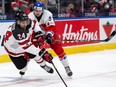 Team Canada’s Justin Sourdif (24) battles Team Czechia’s David Moravec (8) during the International Ice Hockey Federation world junior championships at Rogers Place in Edmonton on Dec. 26, 2021.