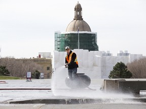 The dome of the Alberta legislature is visible in the background as crews clean Violet King Henry Plaza in Edmonton on May 4, 2022.