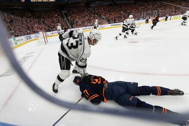 Edmonton Oilers' Connor McDavid (97) is knocked down by L.A. Kings' Dustin Brown (23) during first period NHL Stanley Cup playoffs action at Rogers Place in Edmonton, on Saturday, May 14, 2022.