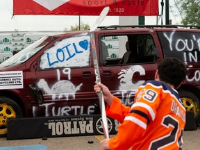 Emmett Mulheron shoots a puck at a Calgary Flames junker van in support of Sports Central at United Cycle in Edmonton, on Wednesday, May 18, 2022. The Edmonton Oilers face the Calgary Flames in Game 1 of their second round series Wednesday.